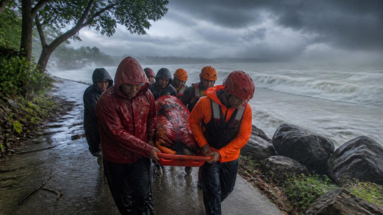 Equipe de resgate em operação sob chuva forte enquanto nuvens de tempestade se aproximam